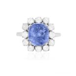 A SAPPHIRE AND DIAMOND CLUSTER RING The central cushion-shaped sapphire weighing approximately 4.