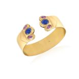 A SAPPHIRE AND PINK SAPPHIRE BANGLE The polished strap, each terminal set with an oval-shaped