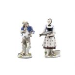 TWO SIMILAR CONTINENTAL PORCELAIN FIGURES, of a male and female fish sellers, standing holding