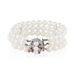A CULTURED PEARL BRACELET WITH RUBY CLASP, composed of three rows of round-shaped cultured pearls