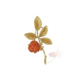 A CORAL AND GOLD FLOWER BROOCH, designed as a stylised rose, the flowerhead carved in coral with