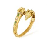 AN EMERALD AND DIAMOND BANGLE, the hinged bangle composed of two ram's head highlighted with