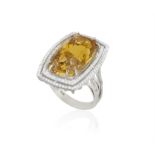 A CITRINE AND DIAMOND COCKTAIL RING, the elongated cushion-shaped citrine weighing approximately 17.