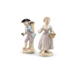 A PAIR OF MEISSEN FIGURES Modelled as a boy carrying a basket of grapes and a girl with a