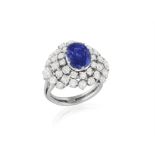 A SAPPHIRE AND DIAMOND CLUSTER RING, ITALIAN, CIRCA 1960, set with an oval-shaped sapphire at the