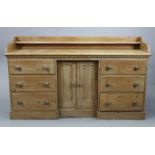 A Victorian pitch-pine inverted break-front dresser base fitted with an open shelf to the low-