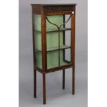 An Edwardian mahogany small china display cabinet with a blind fret-work frieze, fitted two