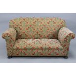 An early 20th century drop-end two-seater settee with rounded back, scroll-arms & sprung seat