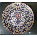 An Imari pattern charger with a foliate border, the centre decorated with bright-coloured vase of