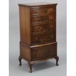 A reproduction mahogany small upright bow-front chest fitted five long graduated drawers with