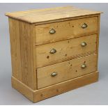 A Victorian pine small chest fitted three long graduated drawers with brass cup handles, & on a