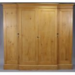 A VICTORIAN PINE BREAK-FRONT THREE SECTION WARDROBE with moulded cornice, enclosed by four panel
