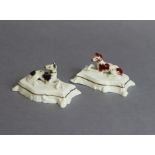 A pair of early/mid-19th century English porcelain models of recumbent greyhounds, each on shaped