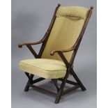 A mahogany frame elbow chair on X-shaped supports with padded seat & back upholstered fawn-