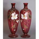 A pair of Victorian pink glass slender ovoid vases with enamelled floral decoration, each on round
