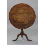 A late 18th century oak tripod table, with three-board circular top on vase-turned centre column &