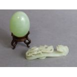 A Chinese jade belt hook of pale celadon colour, finely carved & pierced with a qilong facing the