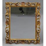 A 20th century Florentine carved & pierced giltwood frame rectangular wall mirror, 21” wide x 25.