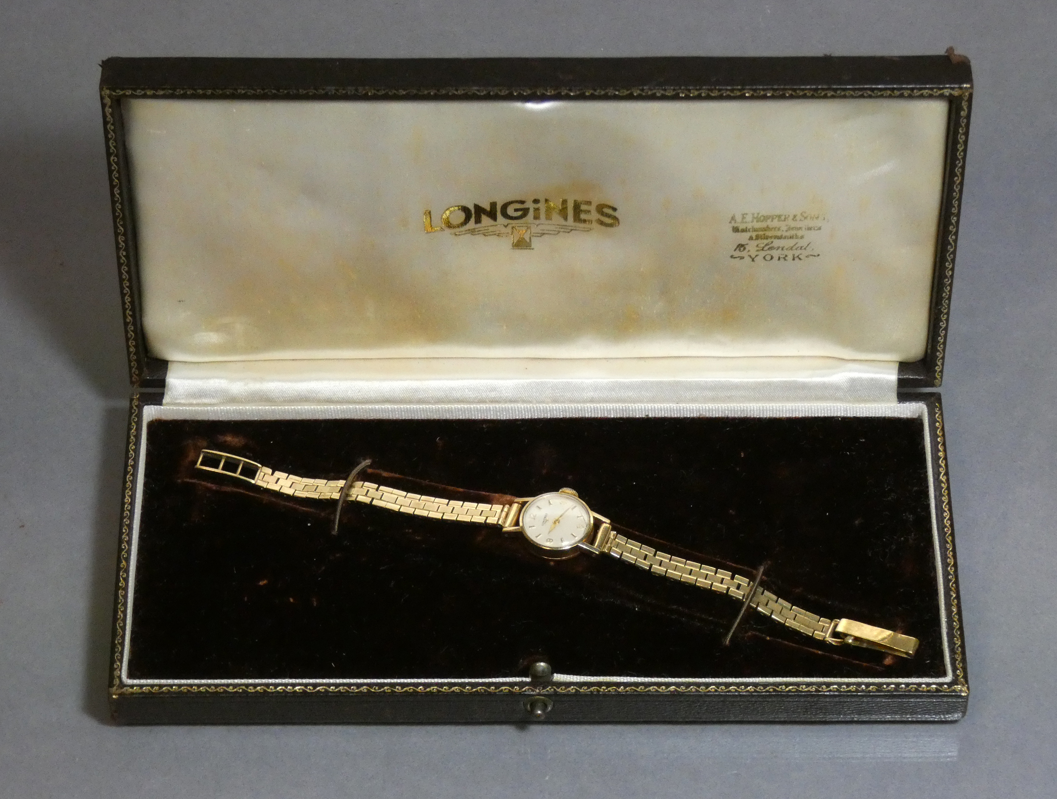 A Longines 9ct gold ladies’ wristwatch, the small circular white dial with gold baton numerals &