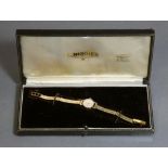 A Longines 9ct gold ladies’ wristwatch, the small circular white dial with gold baton numerals &