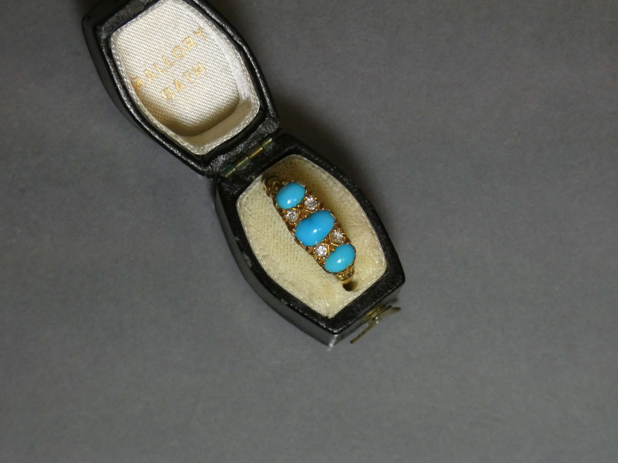 A late Victorian gold ring set three graduated turquoise cabochons with pairs of small diamonds in - Image 2 of 3