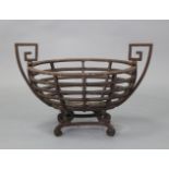 A 19th century cast iron oval fire grate with angular side handles, 25½” wide x 17” high x 12”