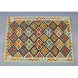 A Choli kilim rug of ivory ground with repeating multi-coloured lozenge design & narrow border,