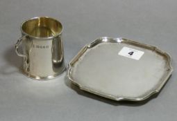 An Edwardian silver square card tray with rounded corners & raised moulded border, on four bun feet,