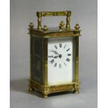 A carriage clock in decorative gilt-brass case, the white enamel dial with black roman numerals &