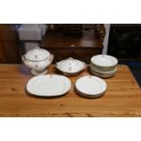 An English porcelain 17-piece part dinner service with gilt rims and monogrammed crest,