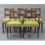 A set of five regency mahogany dining chairs, including one carver, with figured panels to the