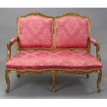 An 18th century style French carved giltwood frame sofa upholstered rose-pink silk damask, on six