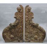 A pair of carved & shaped oak side panels, each featuring a child’s head amongst scrolling
