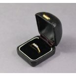 An 18ct. Gold ring set row of three small diamonds; size: L; weight: 2.3 gm.
