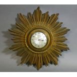 An early/mid-20th century wall timepiece in giltwood sunburst case, with French eight-day