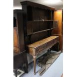 An 18th century oak dresser with open shelves above, fitted two small cupboards, the base fitted