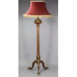 A carved giltwood standard lamp, with gilt metal baluster-shaped terminal above a carved & fluted