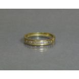 An 18ct gold half-hoop ring set row of ten small baguettes; size N, weight 2.7g.