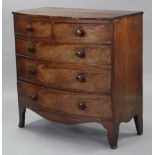 An early 19th century figured mahogany bow-front chest, fitted two short & three long graduated