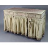 A cream painted wooden serpentine-front knee-hole dressing table fitted three frieze drawers above