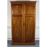 A late 19th/early 20th century mahogany wardrobe with a moulded cornice, enclosed by a pair of