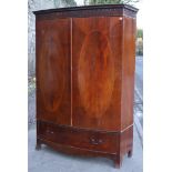 A Sheraton-style inlaid-mahogany bow-front wardrobe with a moulded cornice, enclosed by a pair of