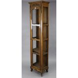A continental-style tall oak-finish cabinet fitted three shelves enclosed by a mesh-fronted door,