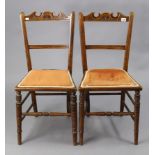 A pair of late Victorian carved beech rail-back occasional chairs with padded seats, & on ring-