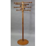 A mid 20th century pine hat & coat stand with turned supports on cylindrical centre column & round