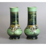 A pair of Royal Doulton stoneware vases with squat round bodies and tall cylindrical necks, with