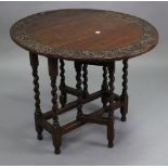 A small oak oval gate-leg table with a carved foliate border, & on barley-twist legs & turned feet