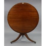 A regency-style mahogany pedestal dining table with a moulded-edge to circular tilt-top, & on a vase
