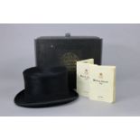 A Lock & Co. of London black silk top hat with hat box.