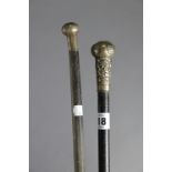 Two ebonised gent’s walking canes, one with a Chinese silver embossed handle, the other with a white